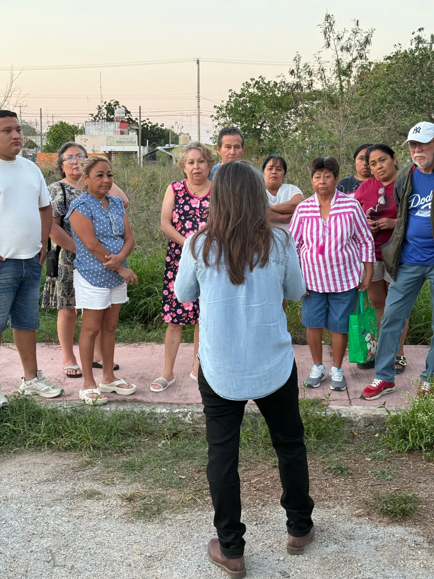 Grupo de personas adultas reunidas alrededor de una mesa con planos.